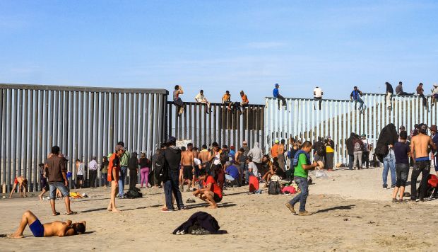Integrantes de la caravana de centroamericanos escalan el muro fronterizo en Tijuana, en el estado de Baja California (México), el pasado martes. (Foto: EFE)