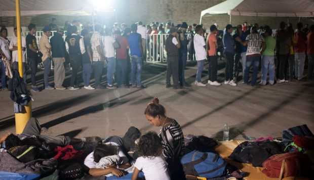 Inmigrantes centroamericanos se alinean para comer y descansar en colchones dentro de una bodega utilizada como albergue en Piedras Negras Coahuila, México. (Foto: AFP)