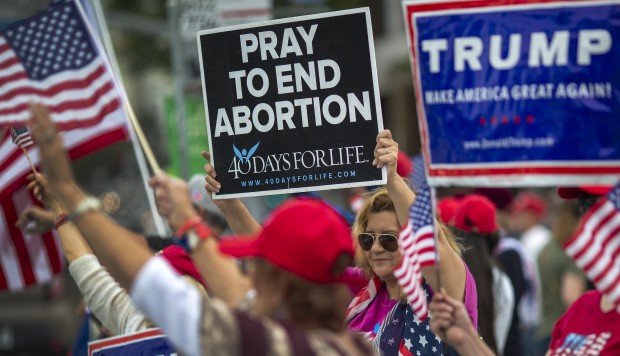 Una mujer sostiene una pancarta contra el aborto como simpatizantes de la manifestación del presidente Donald Trump. (Foto: AFP)