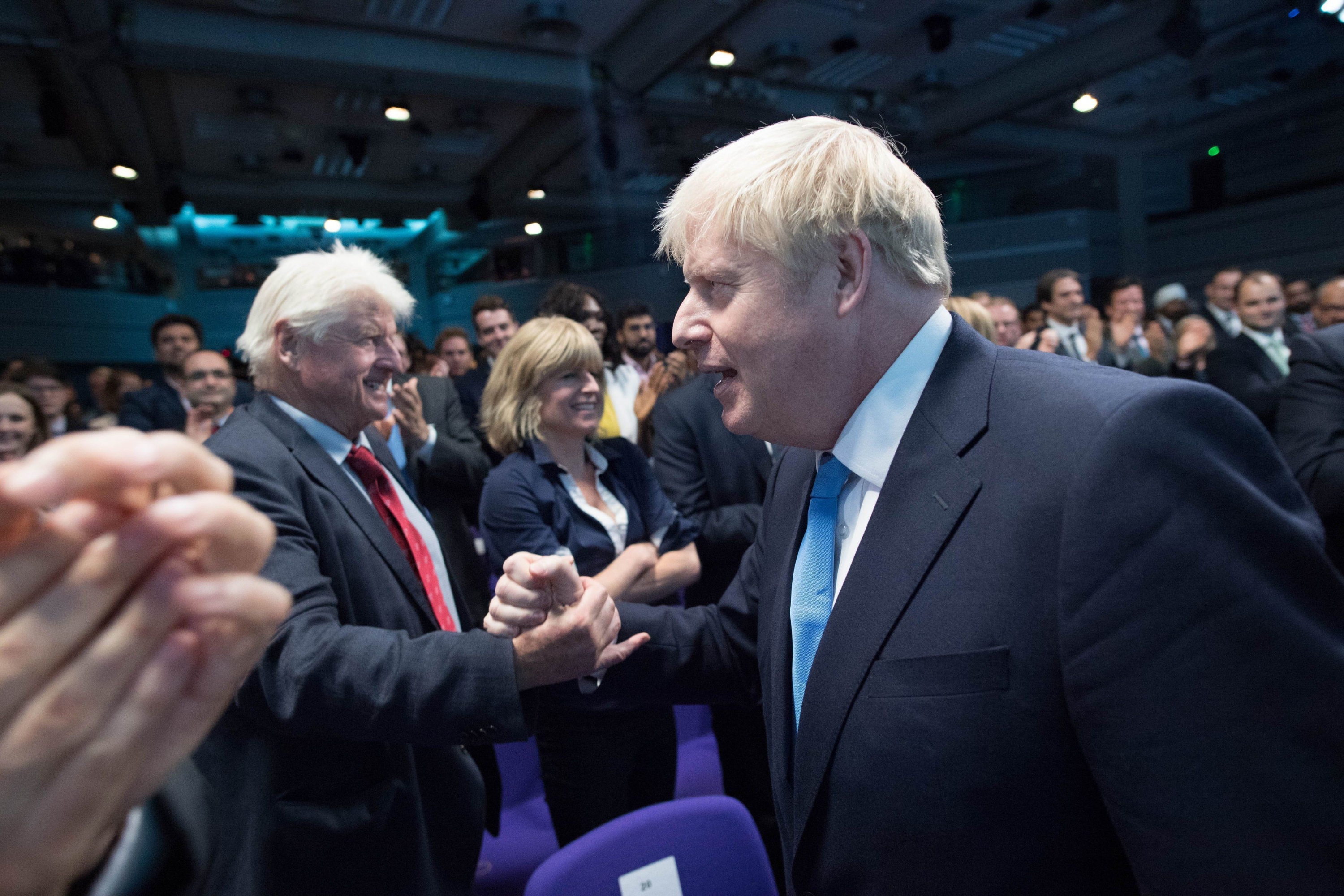 Boris Johnson le da la mano a su padre Stanley Johnson tras el anuncio oficial. (Foto: AFP)
