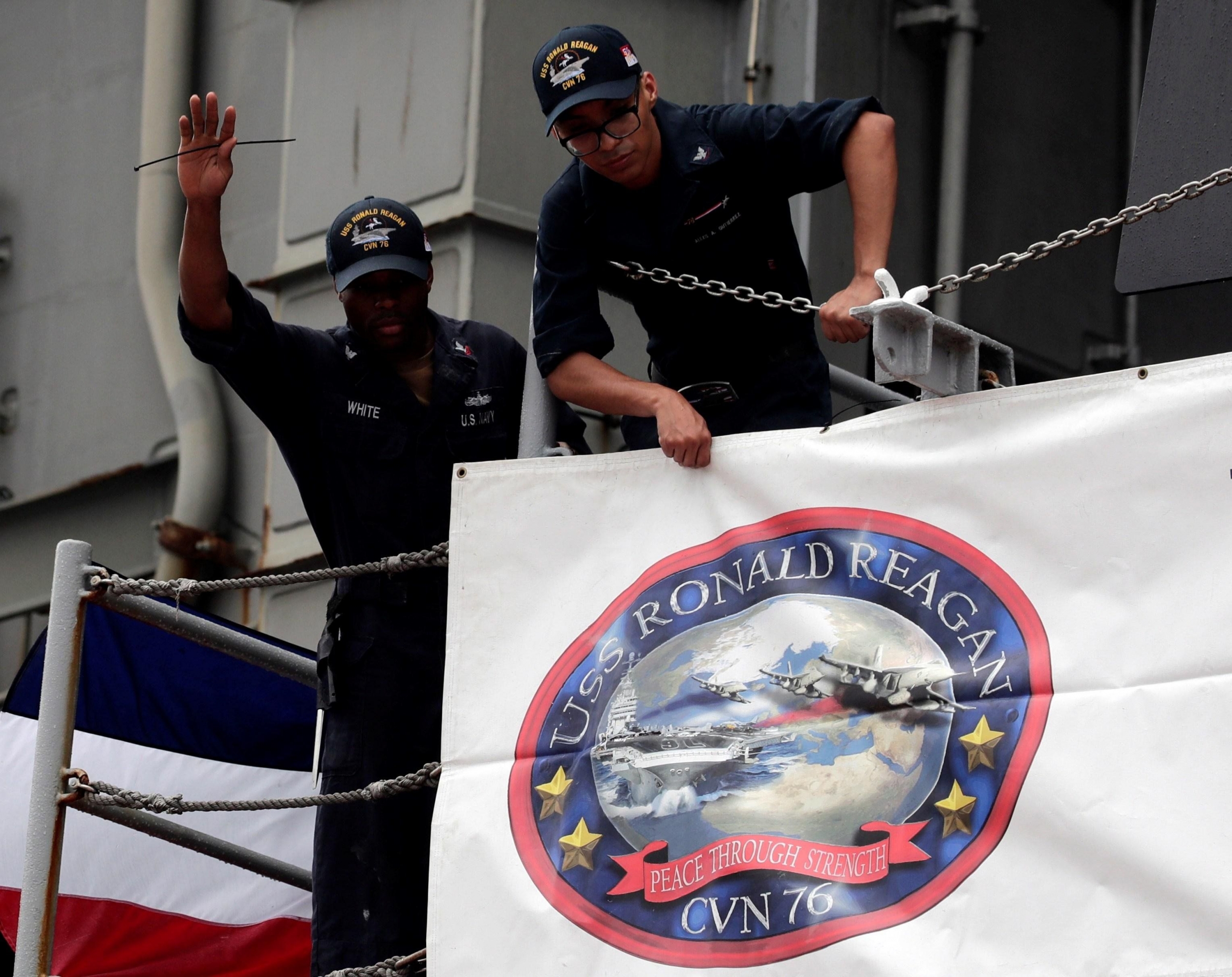 La tripulación instala una pancarta en el portaaviones estadounidense 'USS Ronald Reagan'. (EFE)