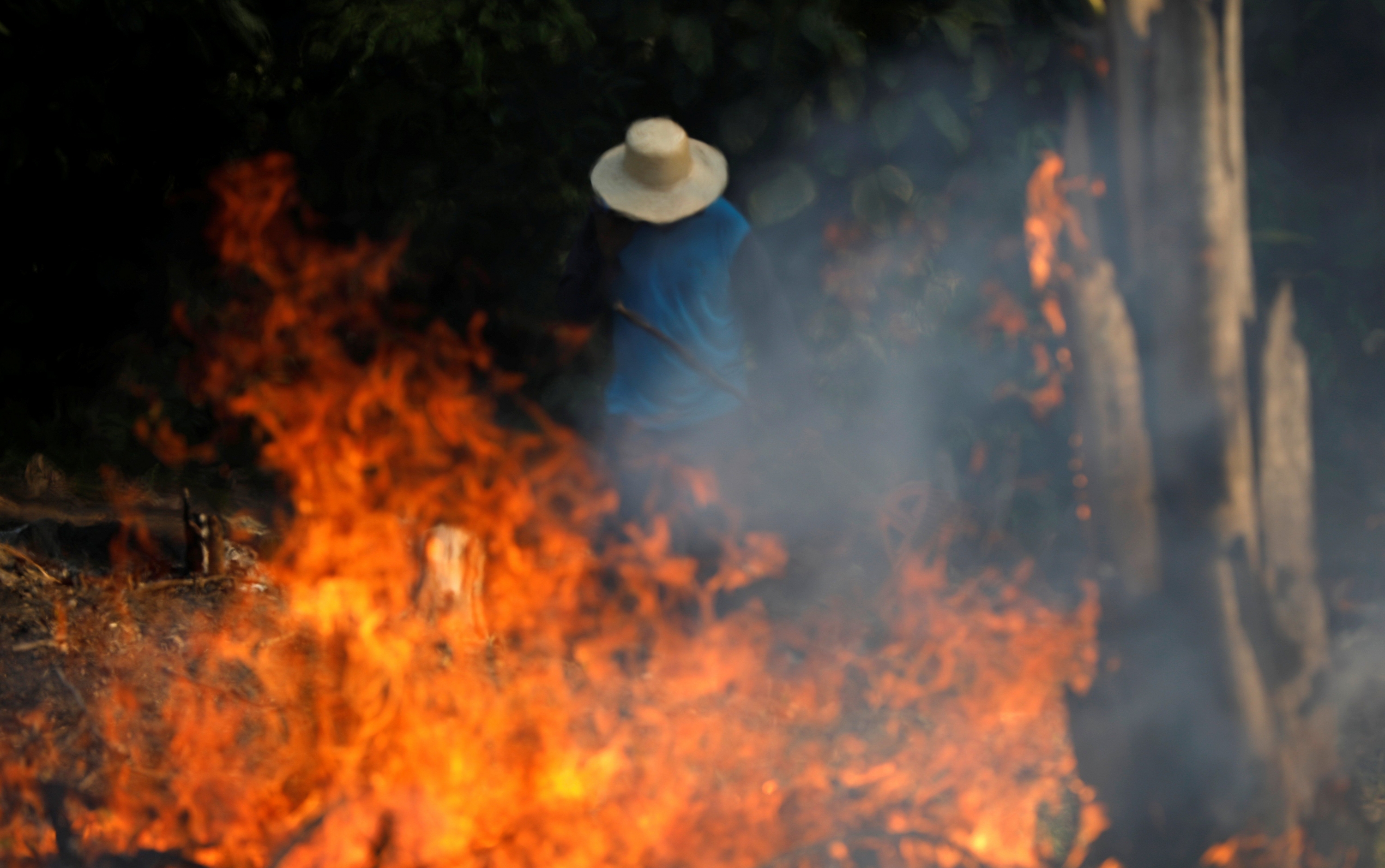 Un hombre trabaja en un tramo en llamas de la Amazonía en Brasil. (Foto: Reuters)